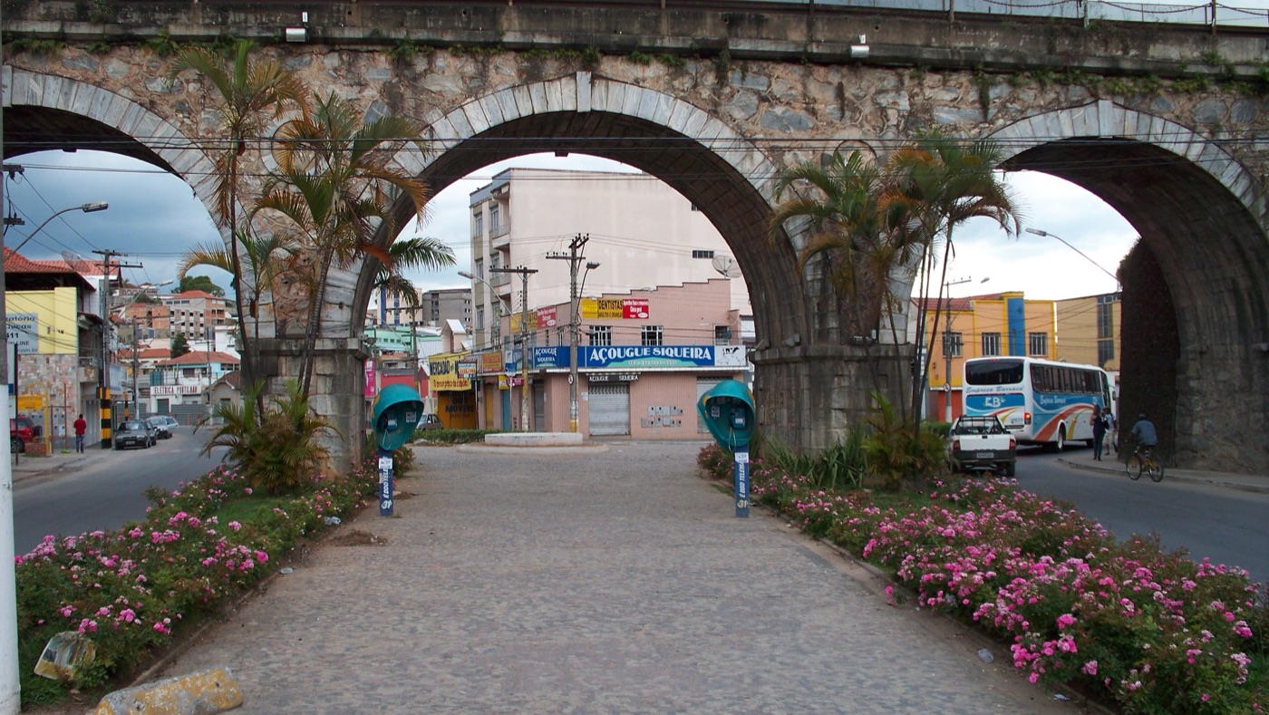 Arcos de pedra do Pontilhão, com canteiros de flores embaixo, em Barbacena